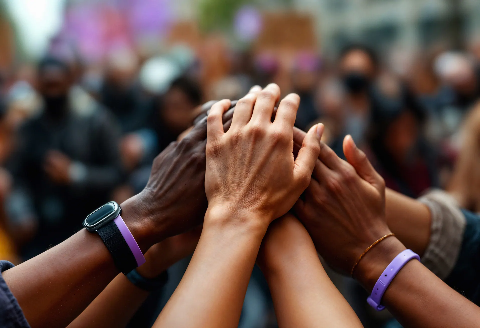 A group of diverse hands stacked together in unity