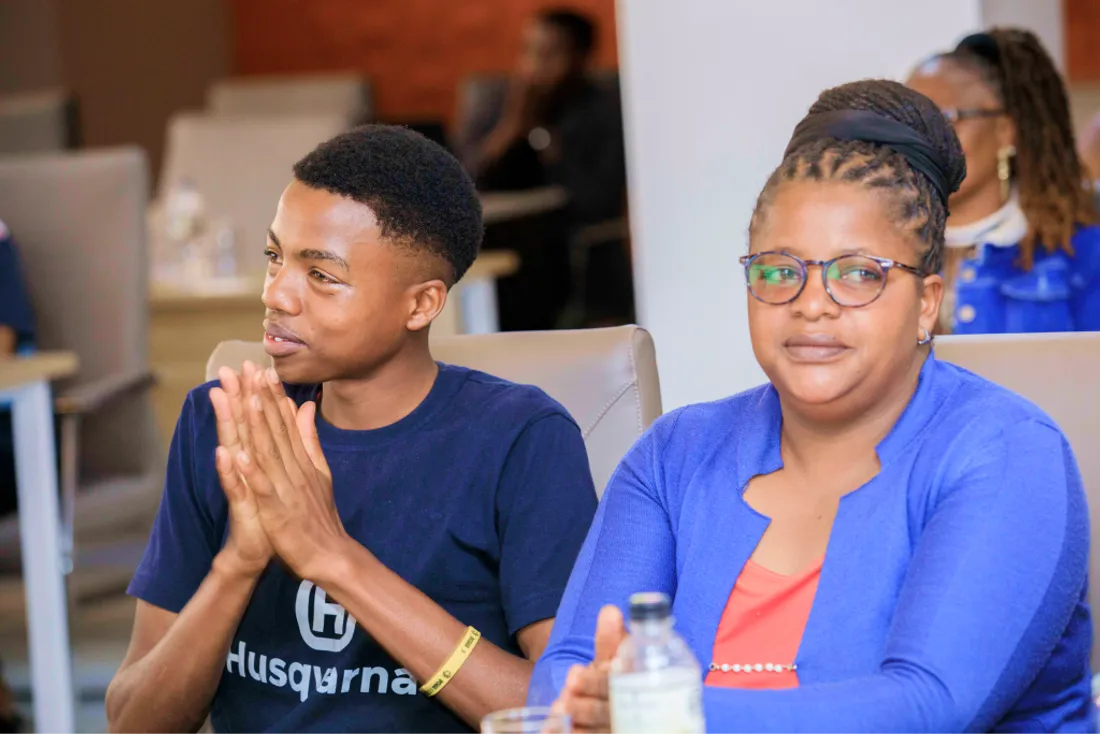 A woman in a blue top seated at a community session