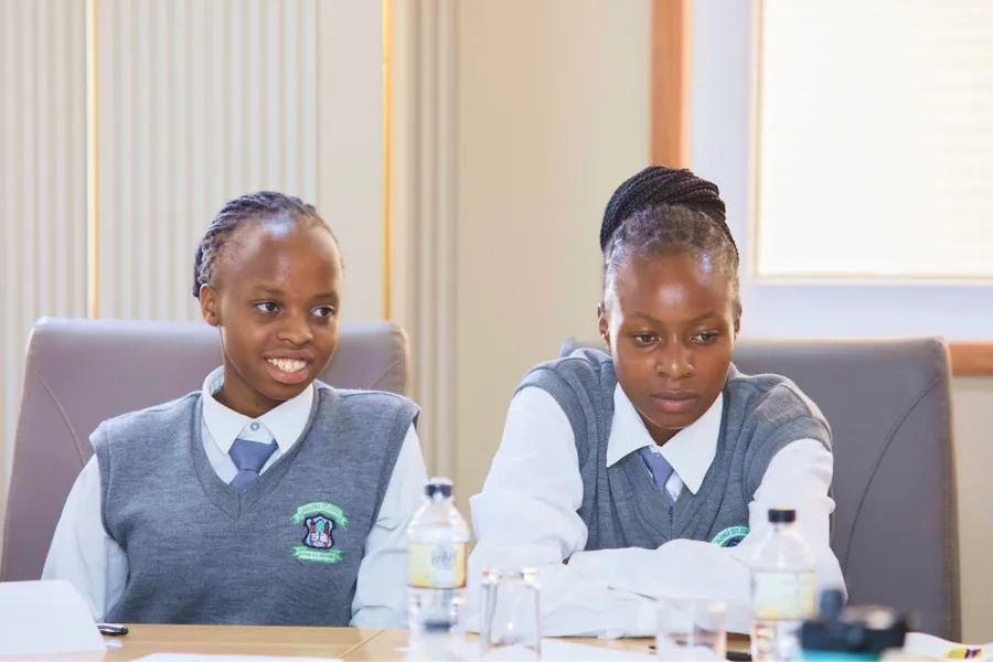 Two students seated at a desk during a Surround Sound Kenya engagement